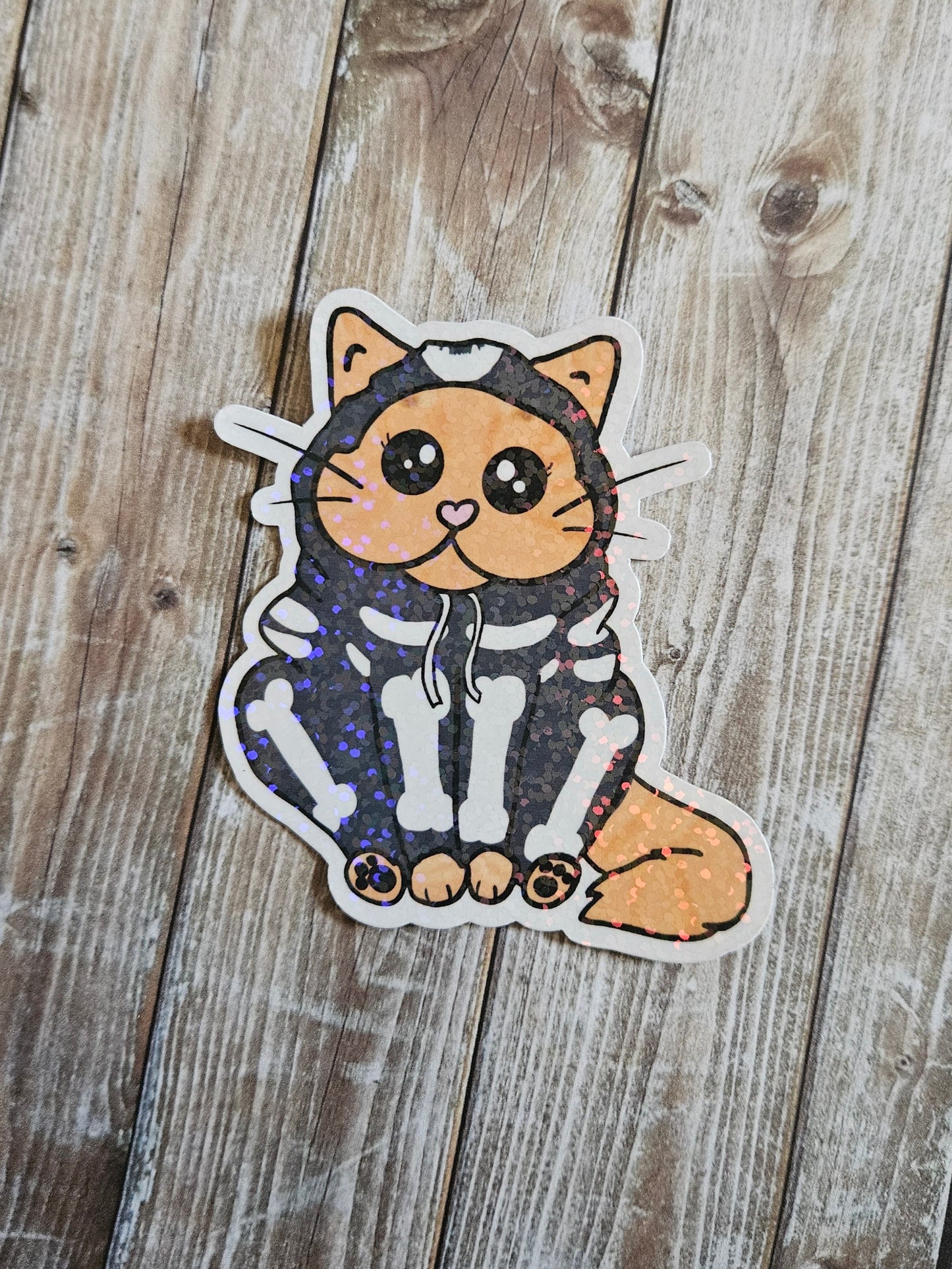 Chonky orange cat in a skeleton hoodie sticker for water bottle