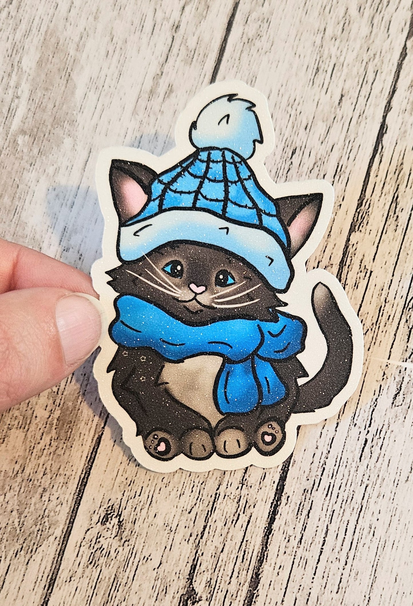 Black kitten with a blue hat and scarf sticker for water bottle