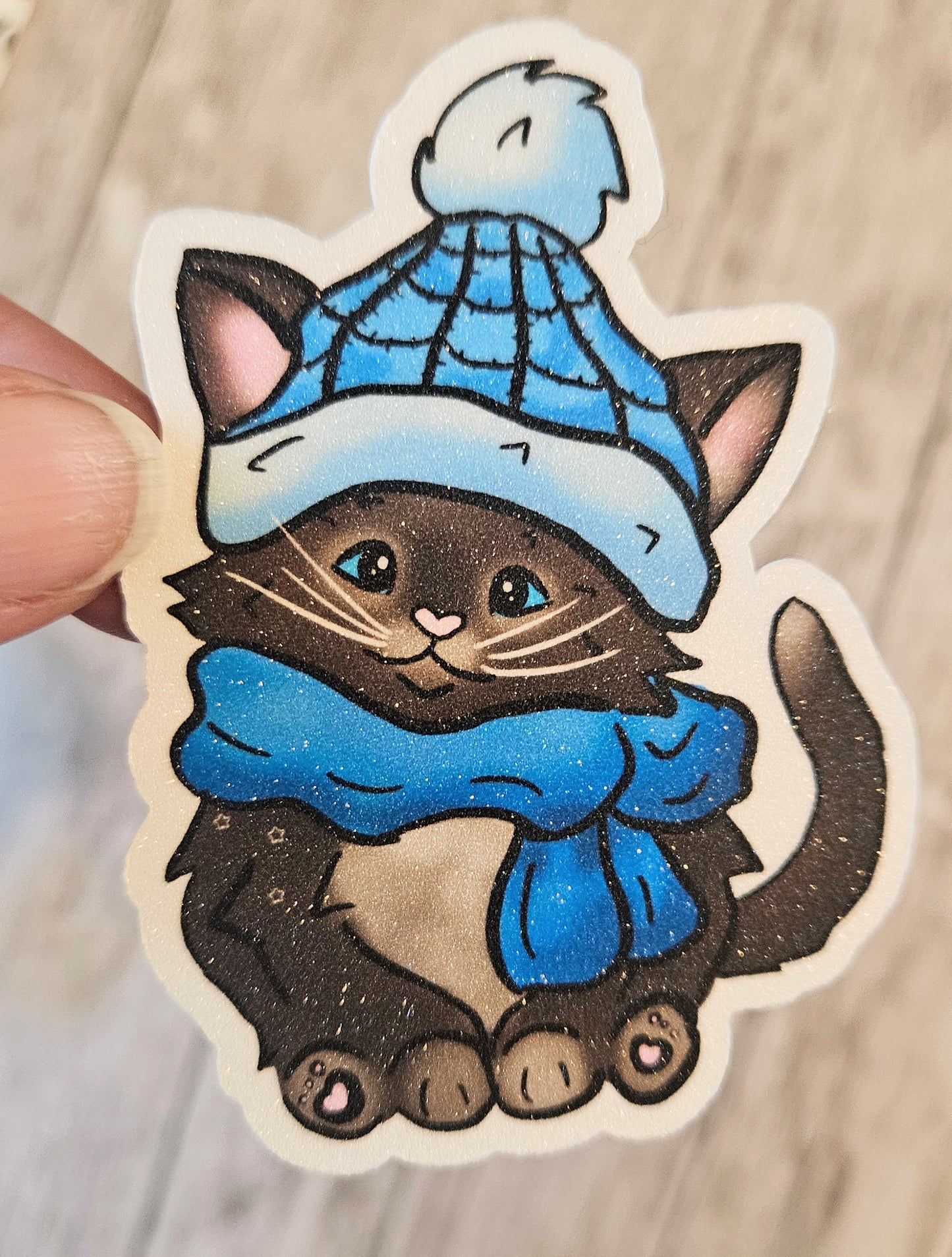 Black kitten with a blue hat and scarf sticker for water bottle